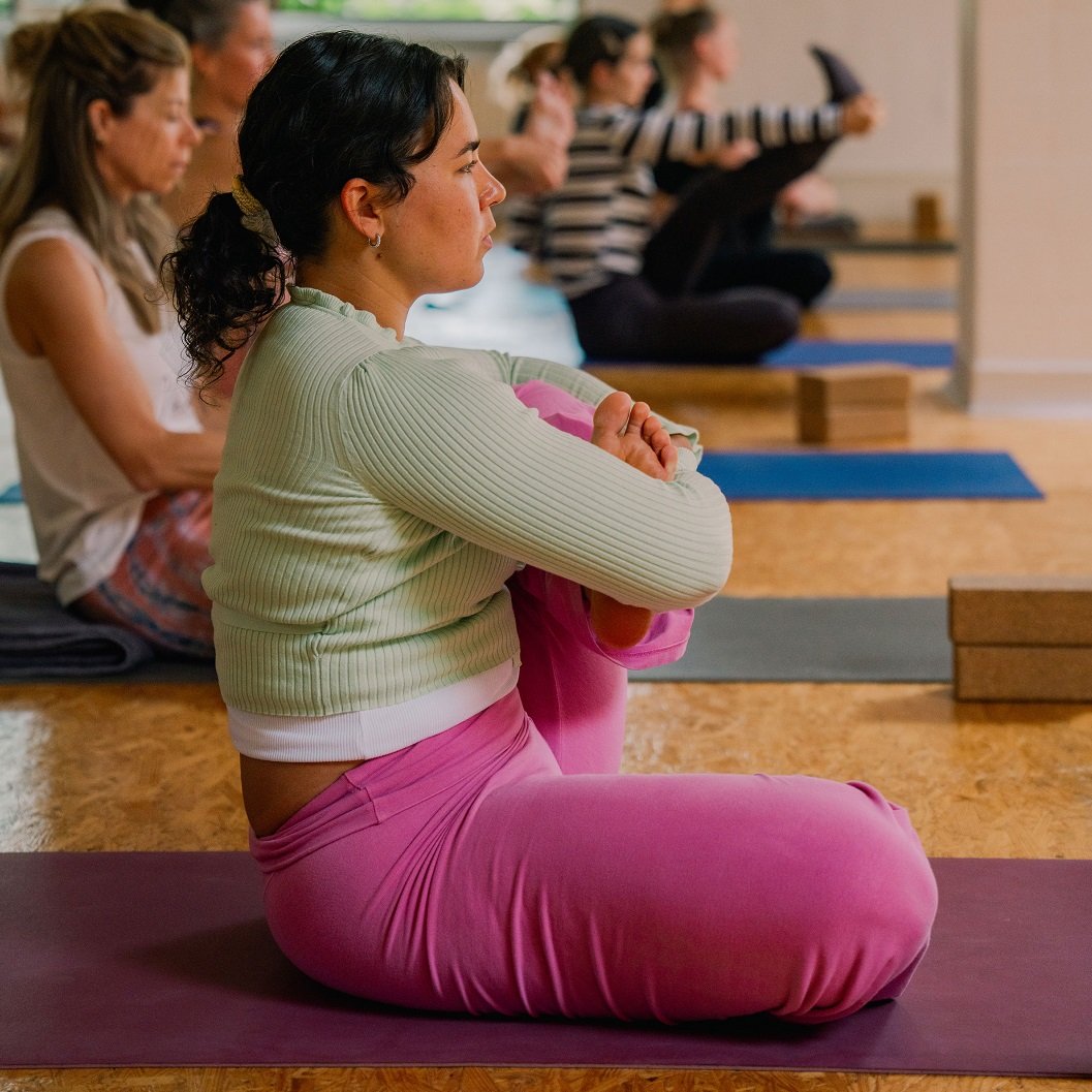 Class Descriptions a picture of a female yoga student in seated Cradle Rock Yoga Asana during an in class photo shooting at the yogashala
